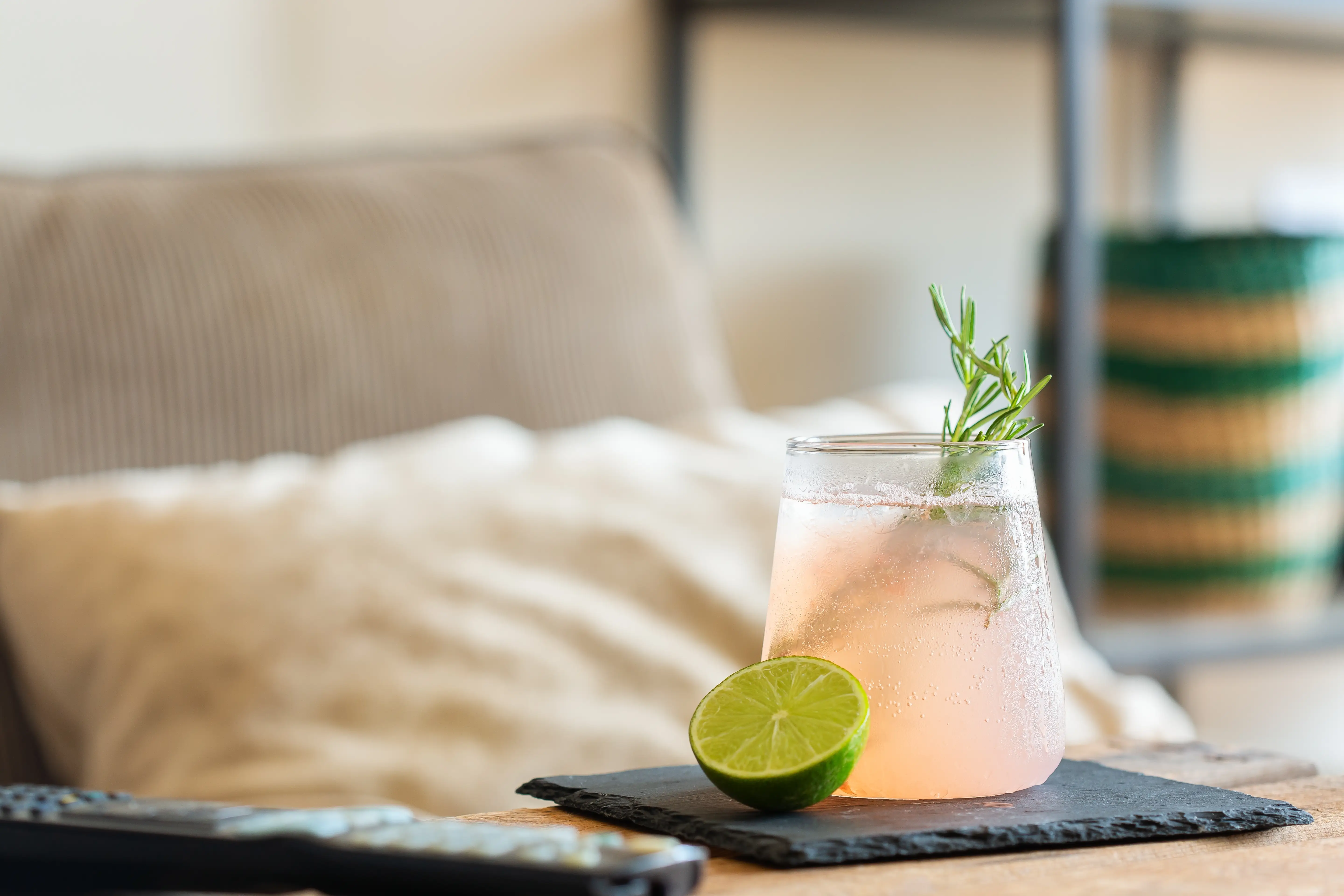 Clear citrus drink with ice and a lime wedge